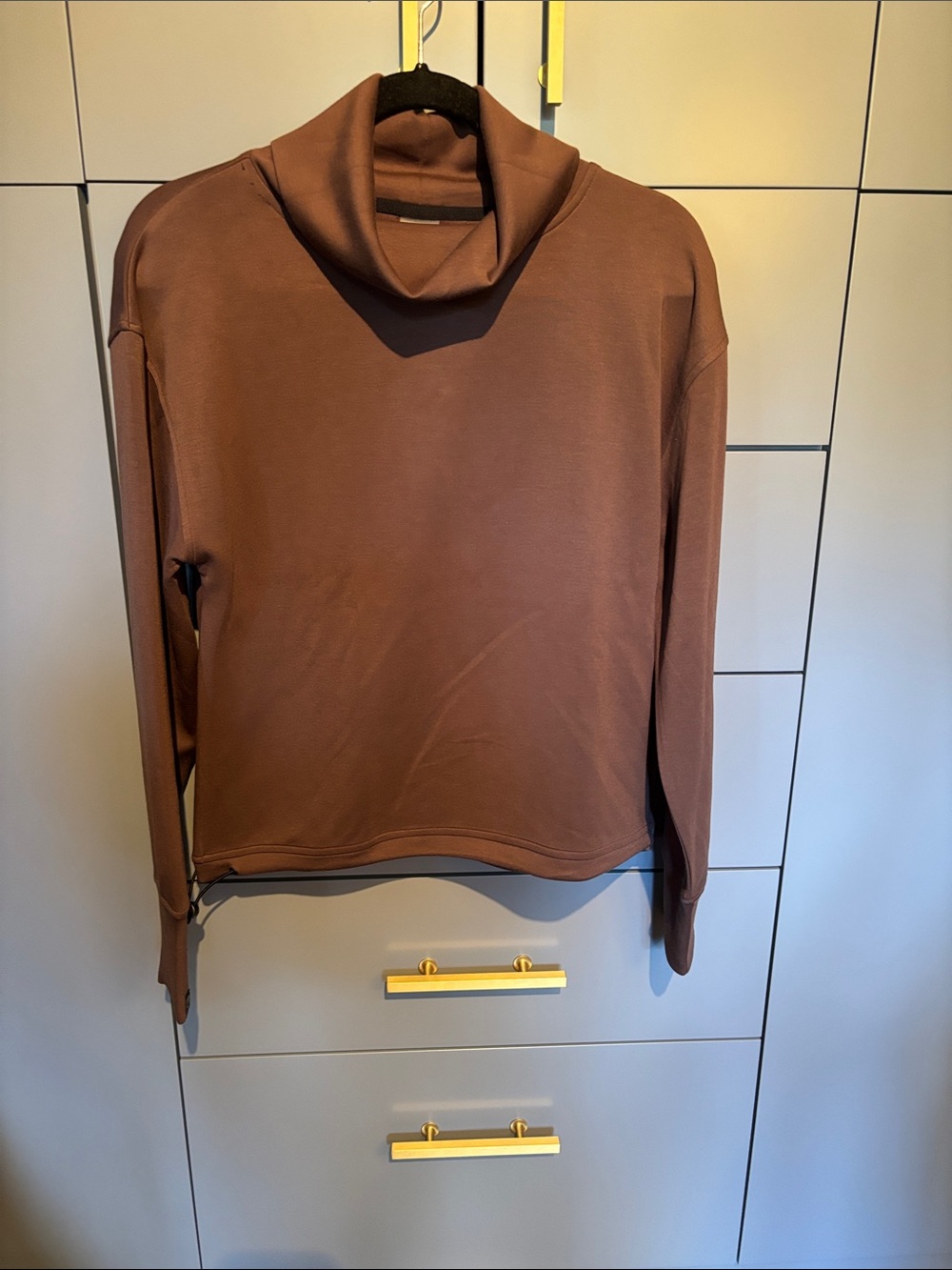 Women’s funnel neck top with split neck line at the back and a toggle closure